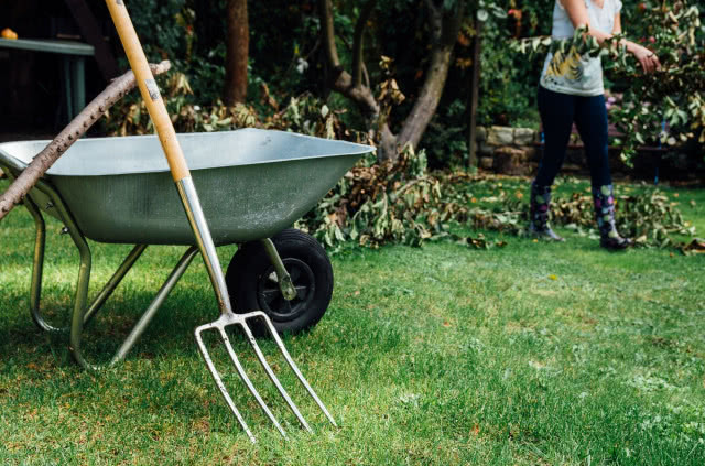 prace ogrodowe z użyciem taczki i grabi