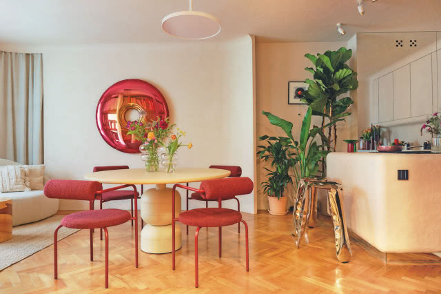 jadalnia z okrągłym stołem i czerwonymi krzesłami