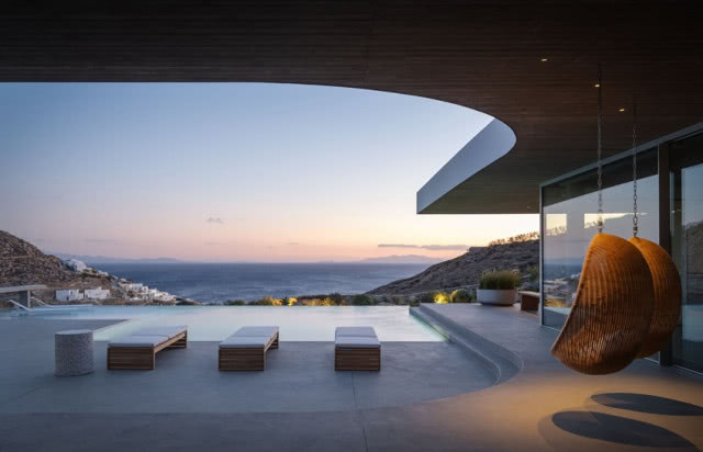 trzy leżaki, basen i ocieniający dach