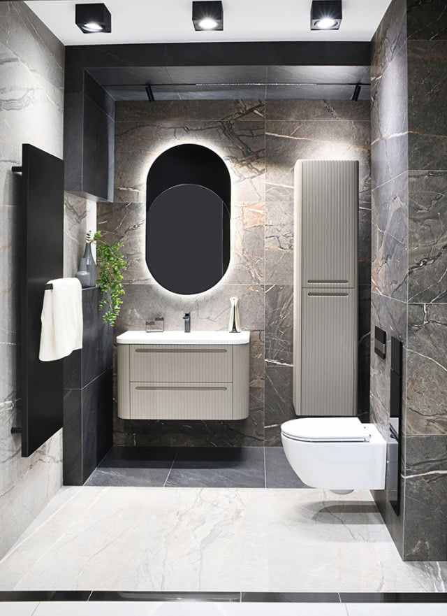 owalne lustro, szafka podwieszana, umywalka, sedes, grzejnik z wieszakiem na ręczniki,