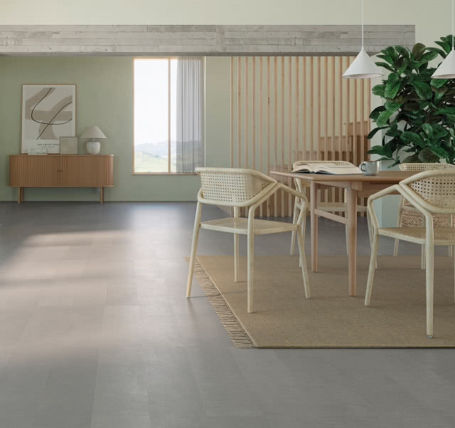 podłoga z betonu, stół z krzesłami, lamele, komoda, duży kwiat zielony, duże okno