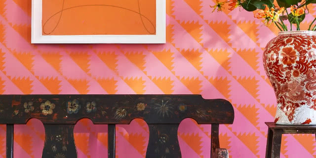 ława malowana na ludowo na tle różowej ściany