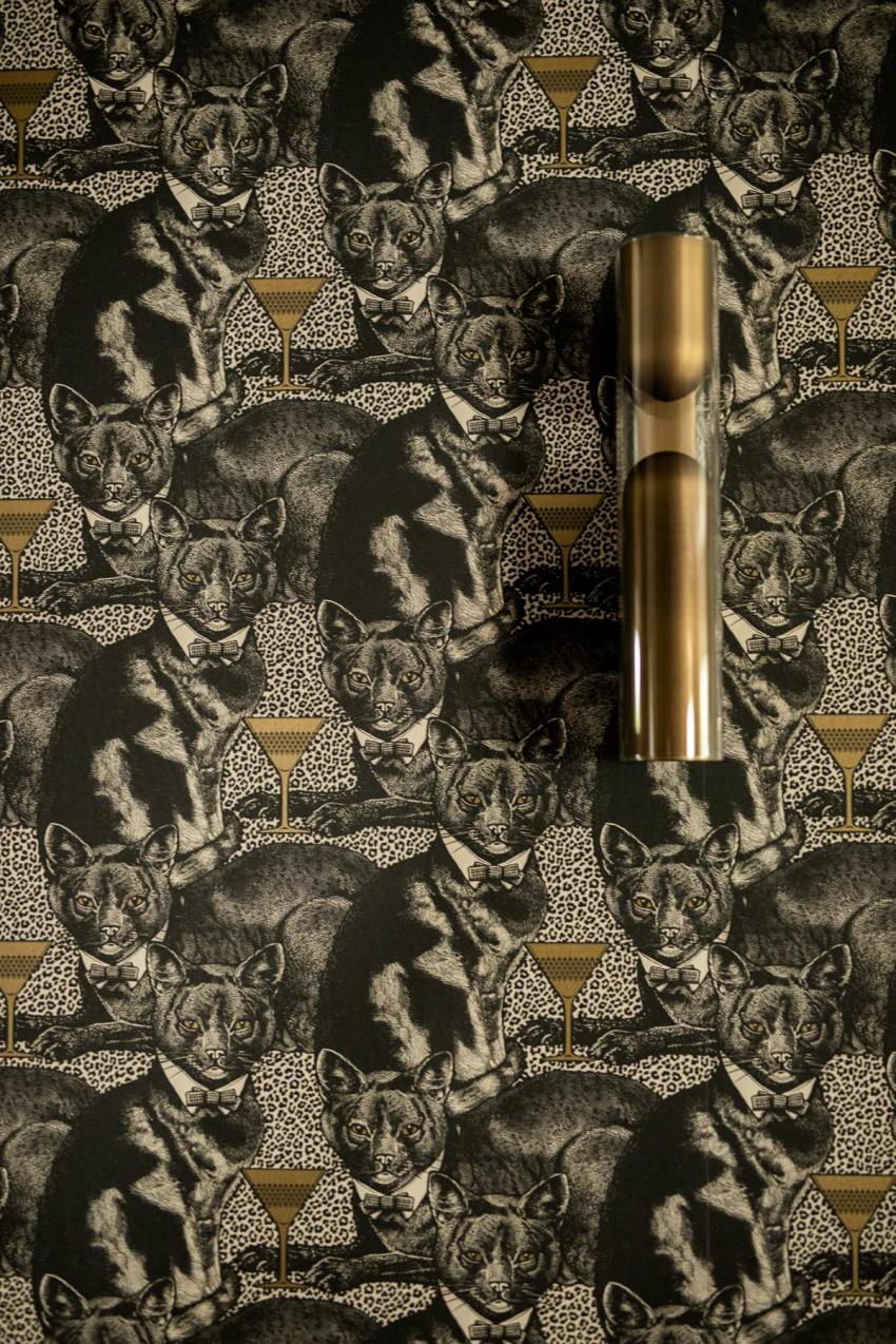 Wzorzysta tapeta zdobi jedną ścianę w salonie