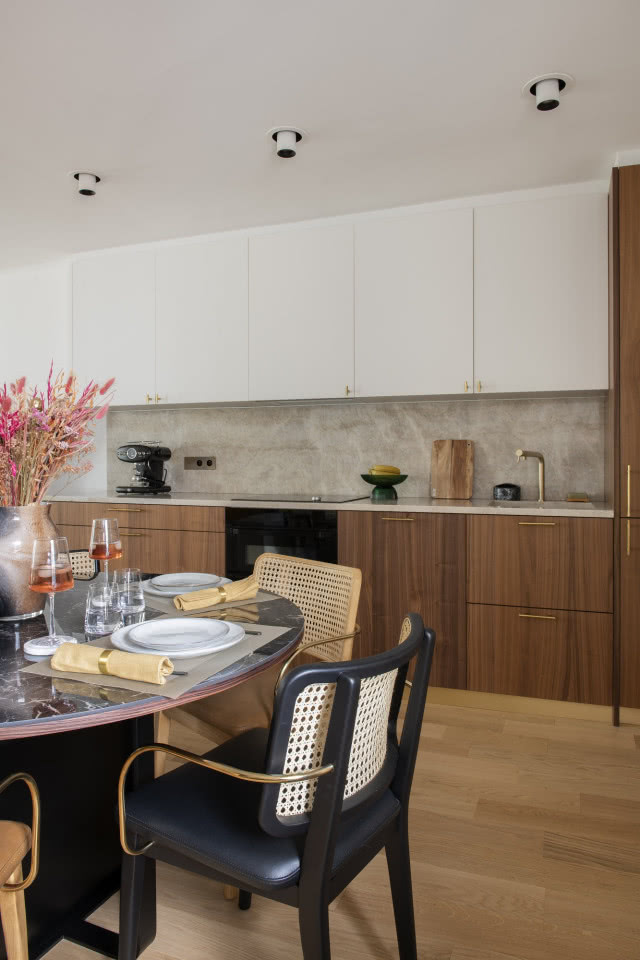 Biała kuchnia z drewnem i krzesłami z plecionki wiedeńskiej