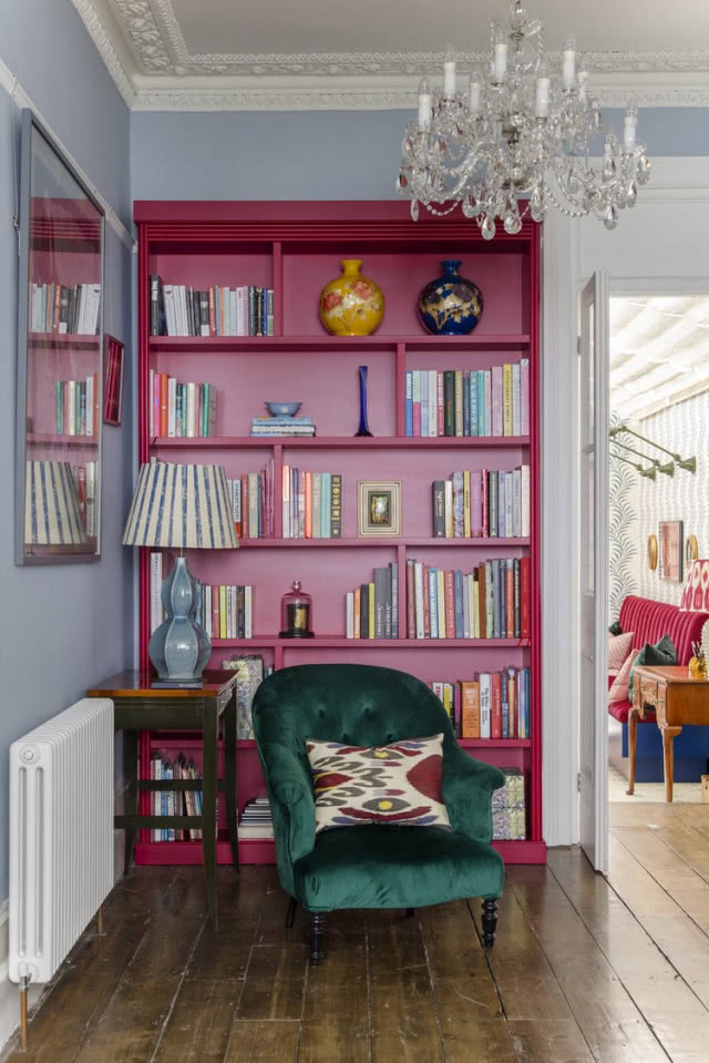 zielony fotel na tle biblioteczki