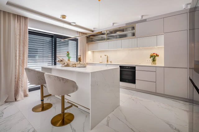 kuchnia urządzona w kolorze białym z wyspą kuchenną