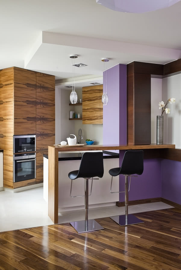 Kuchnia apartamentu z fornirowanymi meblami.