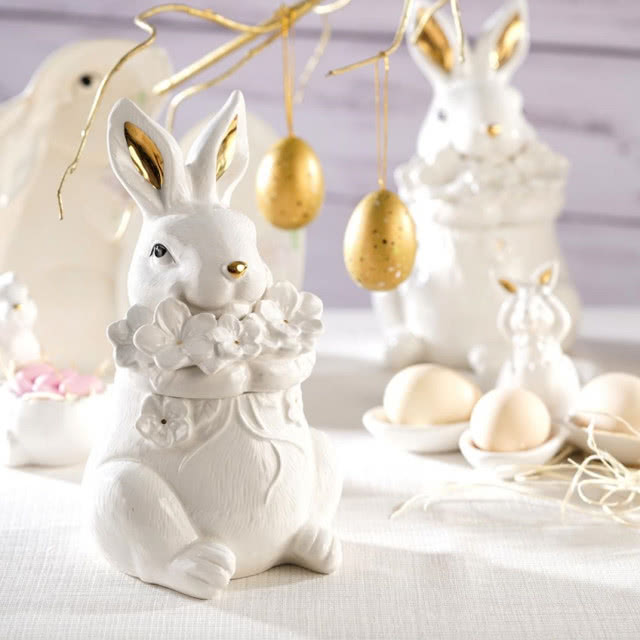 biały zając, który trzyma bukiet kwiatków