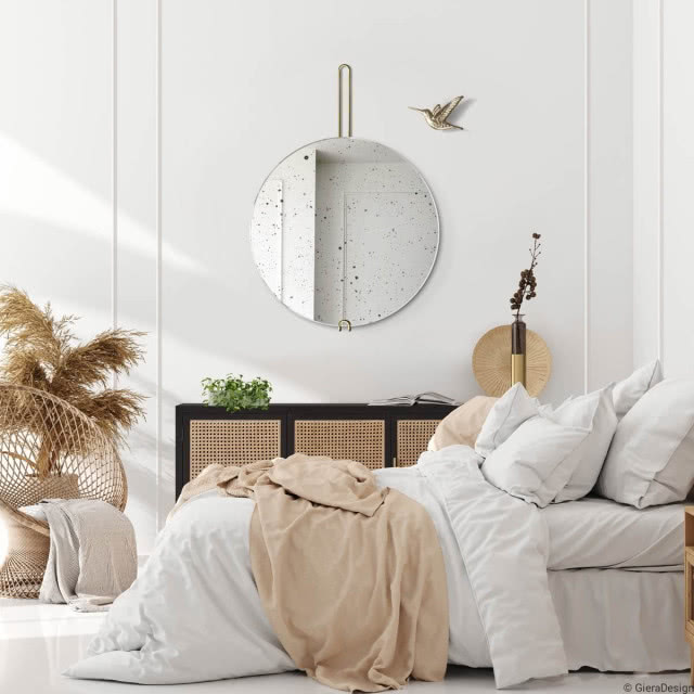 okrągłe lustro z postarzaną taflą szkła nad komodą