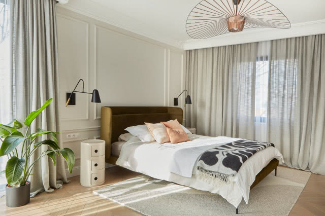 Beżowa sypialnia z zielonym łóżkiem tapicerowanym