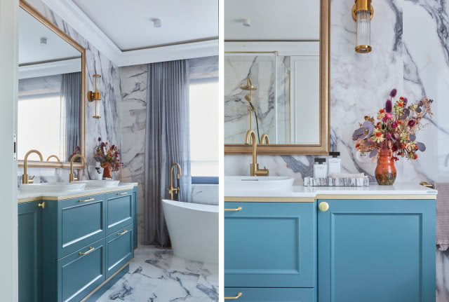 Niebieska szafka łazienkowa w łazience z marmurem