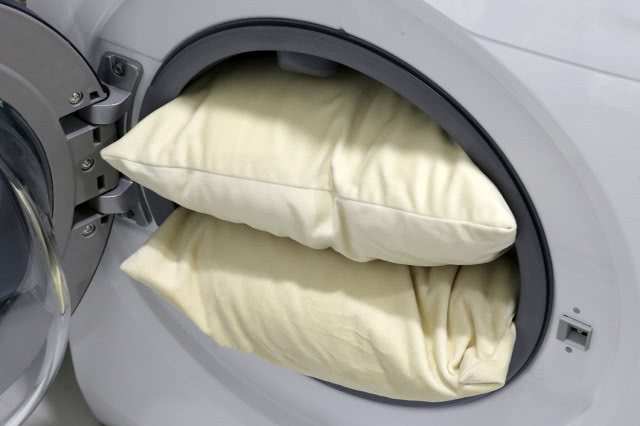 żółte, brudne poduszki wciśnięte do pralki