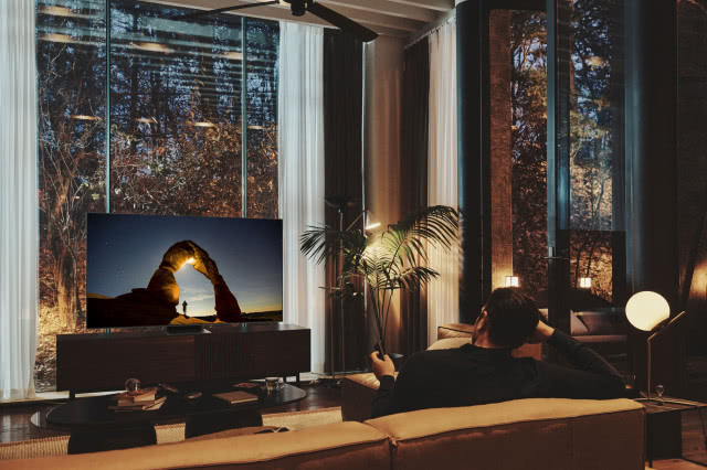 Excellence Line - telewizory dla najbardziej wymagających widzów, kanapa, duże okna, drzewa za oknem, szafka pod telewizor, lampka nocna