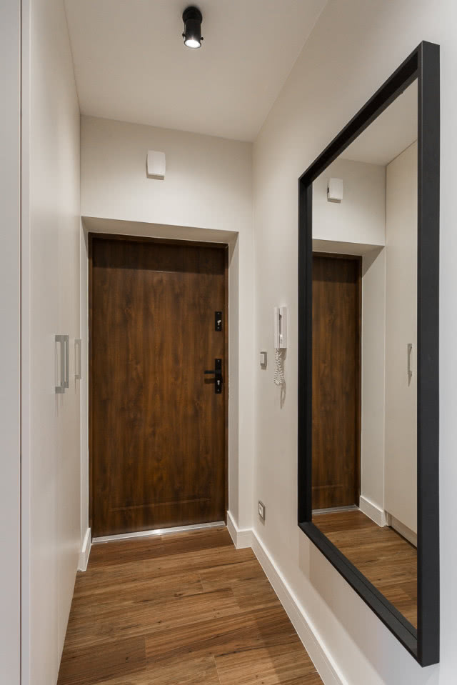 Aranżacja przedpokoju z dużym lustrem