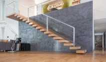 Schody wspornikowe i betonowa ścianka - nowoczesne połączenie we wnętrzu