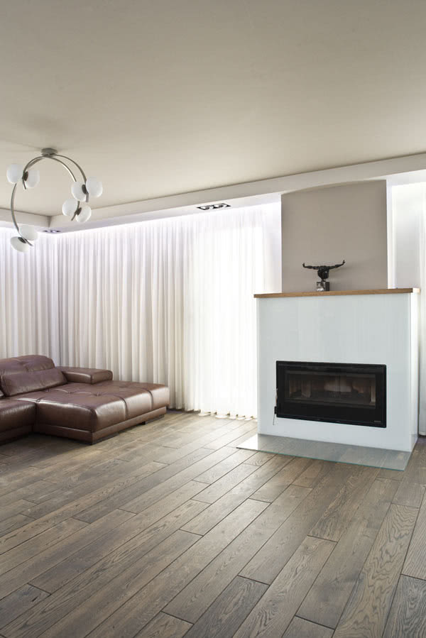 Prostą obudowę kominka wykonano ze szkła...