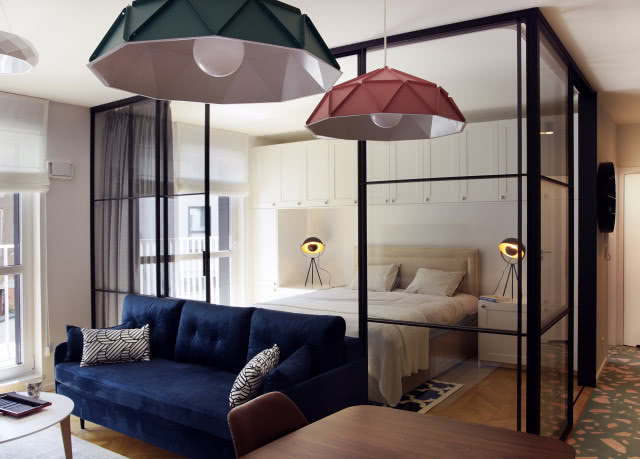 Sypialnia oddzielona szklaną ścianką od salonu