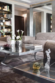Stonowana kolorystyka salonu - beże skórzanych kanap, foteli i jedwabnych dywanów.