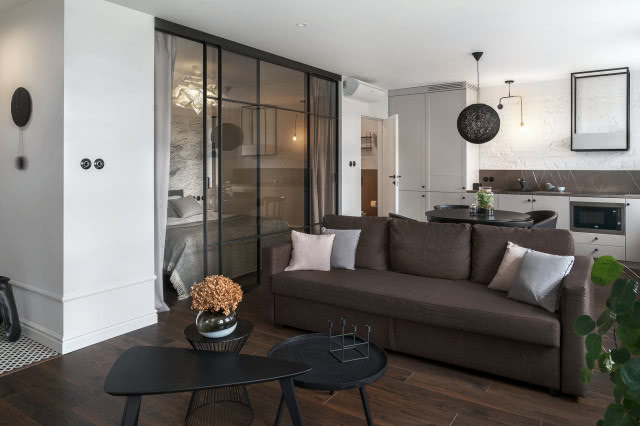 Sypialnia oddzielona szklaną ścianką od salonu