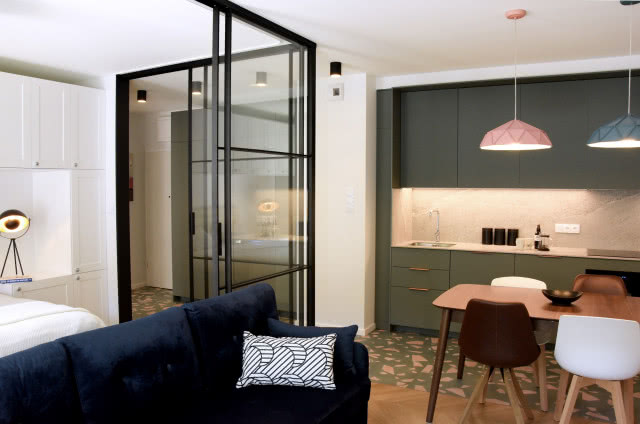 Kuchnia oddzielona szklaną ścianką od salonu