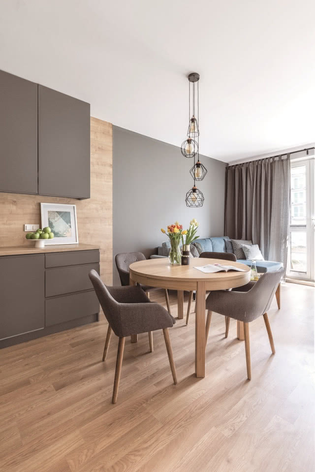 Aranżacja kuchni: Naturalne drewno na podłodze, jednej
ze ścian i na blacie 