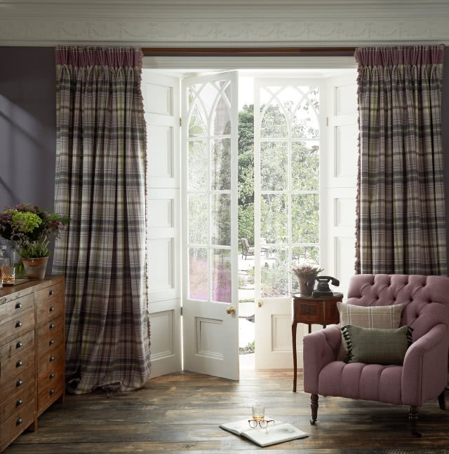 uchylone drzwi z powiewającą firanką, na tle okna fotel