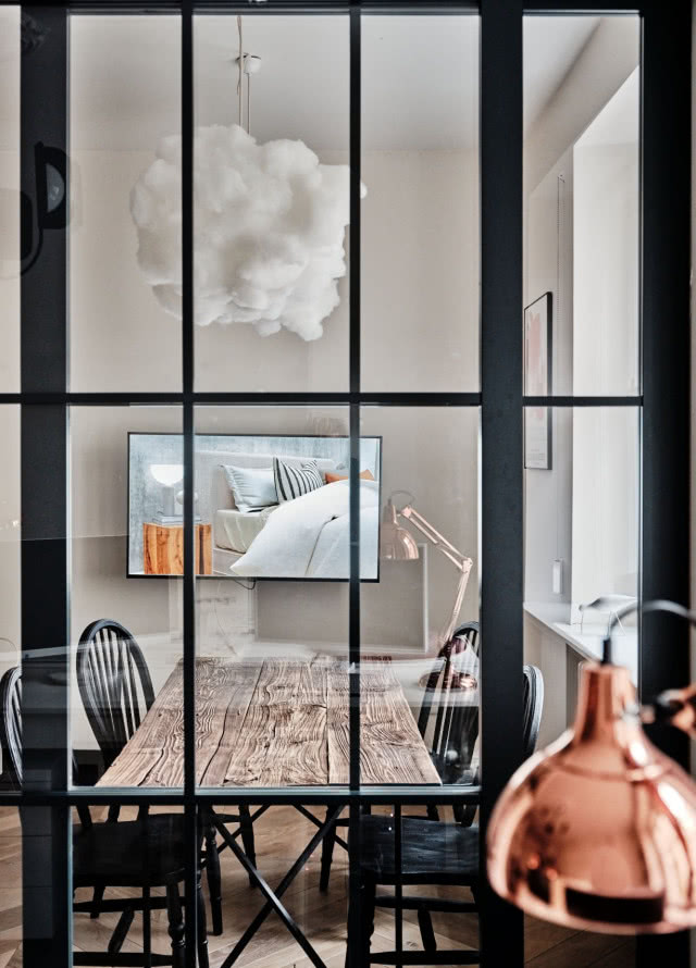 Loftowy stół w pokoju ze szklaną ścianką