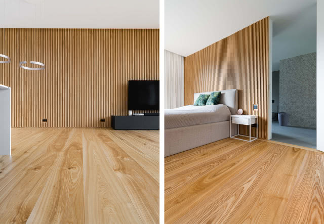 lamele na ścianach, drewniana podłoga, telewizor, szafka pod telewizor, oświetlenie sufitowe. duże łóżko w sypialni, stolik nocny, łazienka