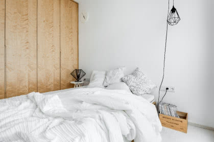 Biała sypialnia z szafą ze sklejki
