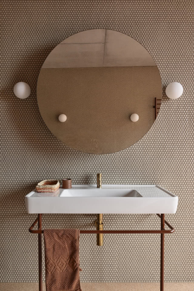 Łazienka z umywalką na metalowym stelażu.