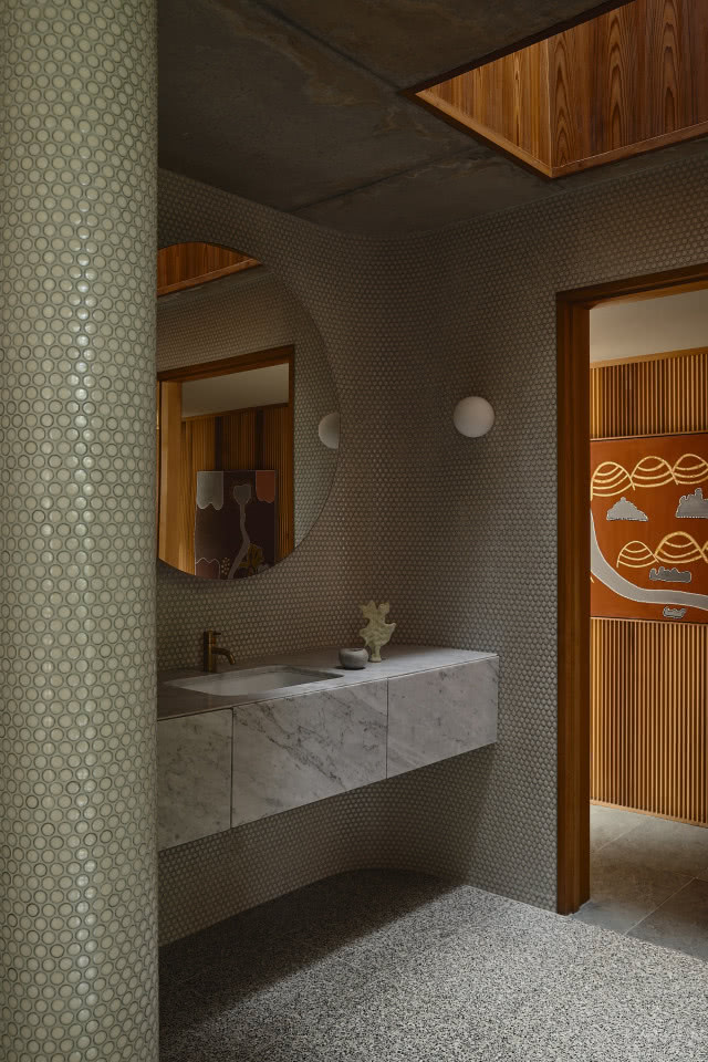 Łazienka z mozaiką na ścianie.