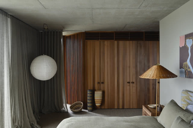 Sypialnia z szafą z ryflowanego drewna.