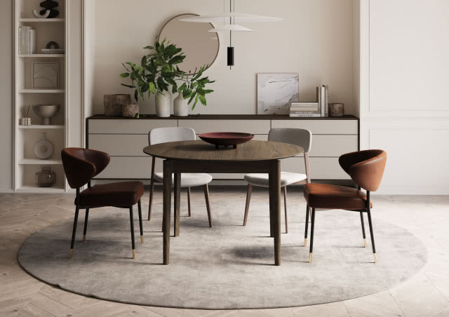 Okrągły drewniany stół z krzesłami w stylu mid-century w eleganckiej jadalni, jasne wnętrze z komodą, rośliną i designerską lampą