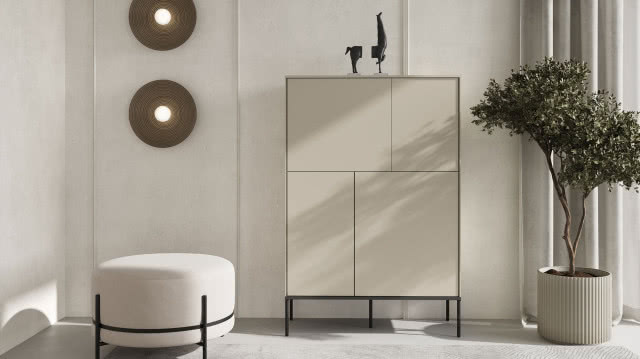 Beżowa komoda o geometrycznych frontach w stylu mid-century, minimalistyczne wnętrze z pufą, rośliną i dekoracyjnym oświetleniem ściennym