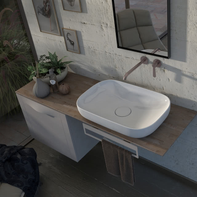 biała umywalka nablatowa, drewniany blat, beton na ścianie, drewniana podłoga, rośliny, olejki zapachowe, ręcznik, biała szafka łazienkowa, lustro, obrazy