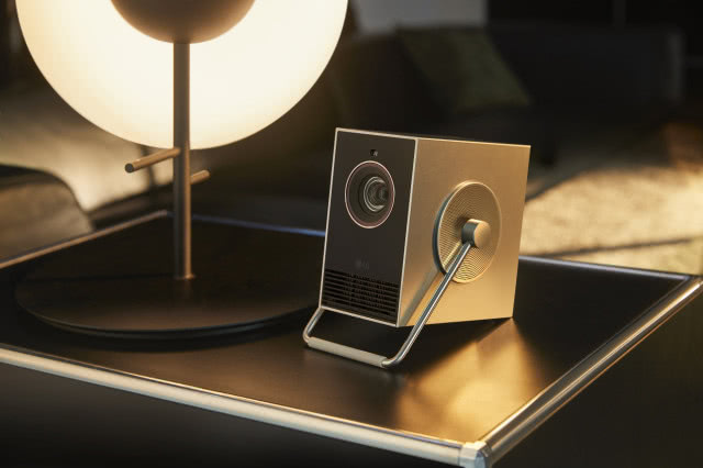 projektor na komodzie obok lampy