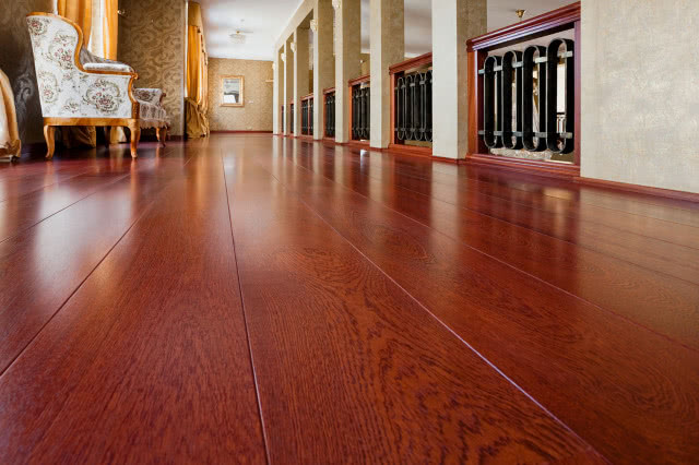 ciemna drewniana podłoga, fotele, barierki, obrazy