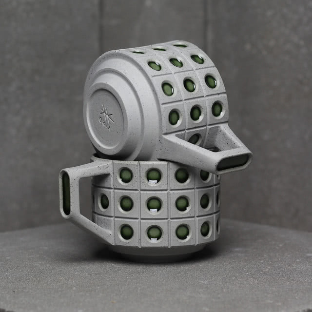 Nowoczesny projekt ceramiczny z geometrycznym wzorem i zielonymi otworami, łączący funkcjonalność z oryginalnym wzornictwem.