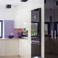 Biały salon i fioletowa kanapa w roli głównej