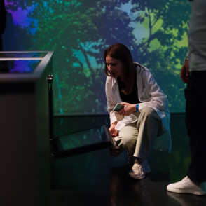 Uczestniczka wydarzenia Midea testuje funkcje piekarnika w immersyjnej przestrzeni prezentującej technologie dla nowoczesnego domu.