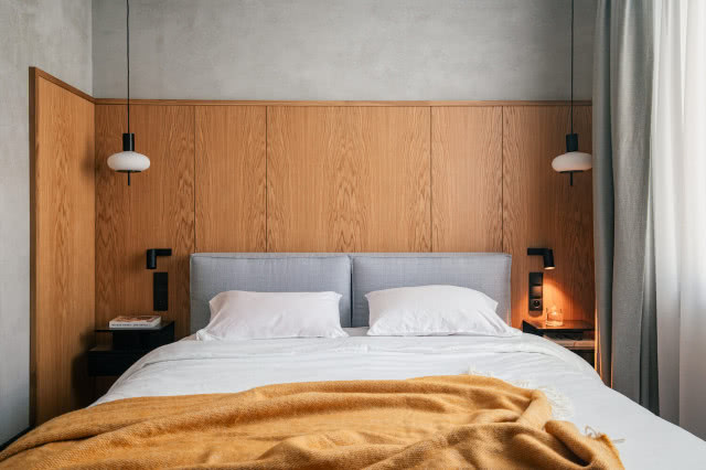 drewniana okładzina na ścianie w sypialni za łóżkiem