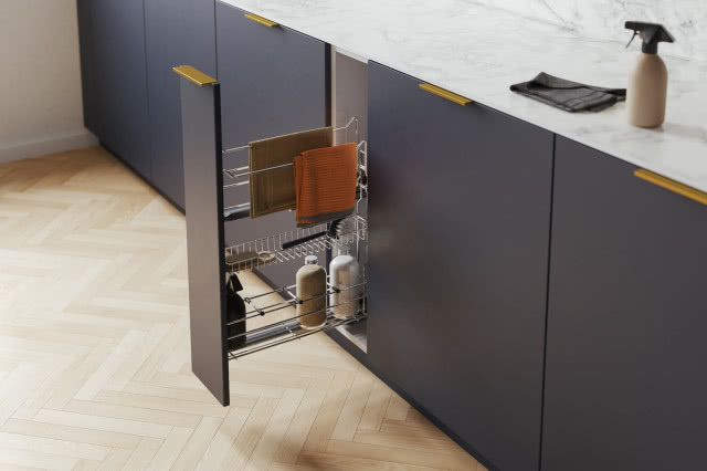 kosz boczny wysuwny, ręczniki, środki czystości, szczotki, szare fronty kuchenne, biały blat, drewniana podłoga