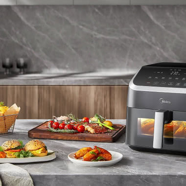 Airfryer Midea na blacie nowoczesnej kuchni podczas przygotowywania chrupiących potraw i domowych posiłków.