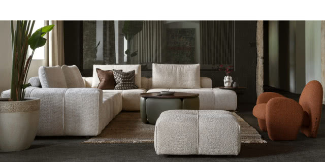 szara sofa z podnóżkiem
