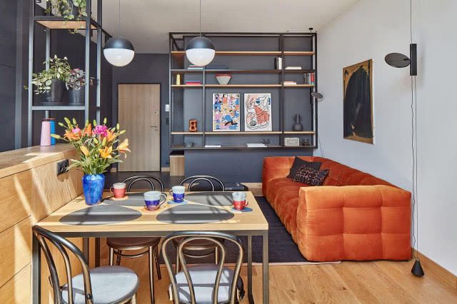 pomarańczowa kanapa w industrialnym salonie