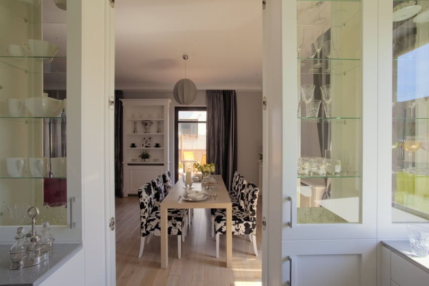 Jadalnię od kuchni oddziela przeszklony kredens...