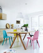 Różnobarwne krzesła przy stole