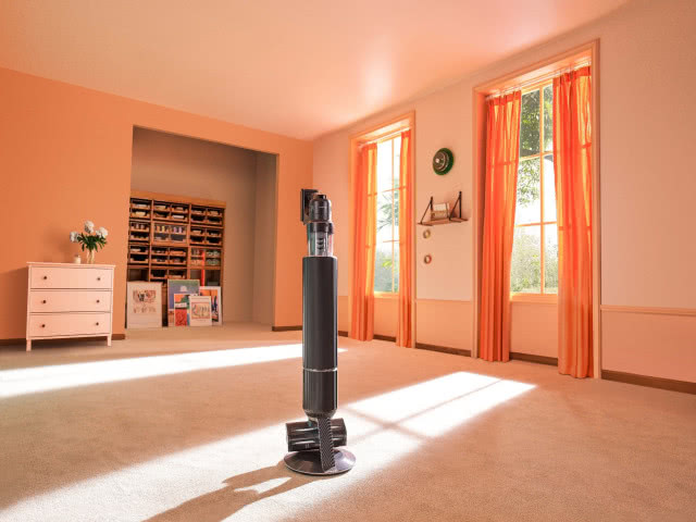 odkurzacz pionowy, duży salon, wykładzina, komoda, półki na zabawki, duże okna, zasłony