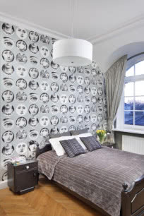 Biało-szara sypialnia z tapetą inspirowaną twórczością Fornasettiego.