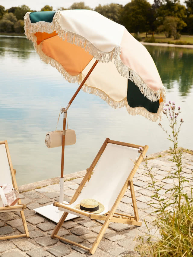 kolorowy prosty parasol na pomoście, pod nim leżak